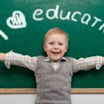 Cheerful smiling child at the blackboard. School concept