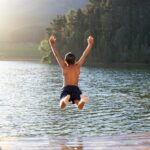 young-boy-jumping-into-lake